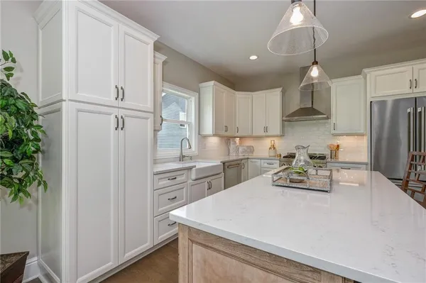 a kitchen with white cabinets and stainless steel appliances