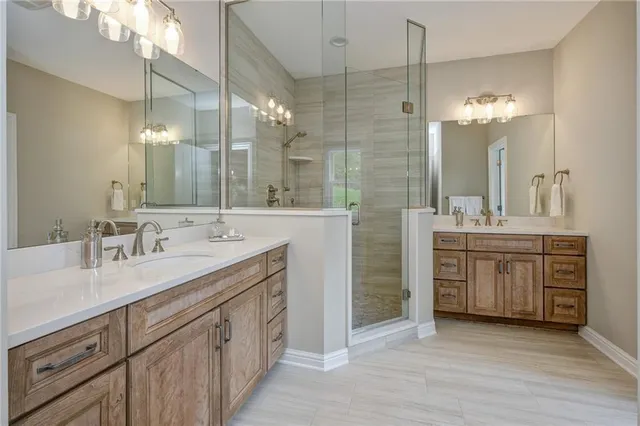 a bathroom with a double vanity sink a mirror and a shower