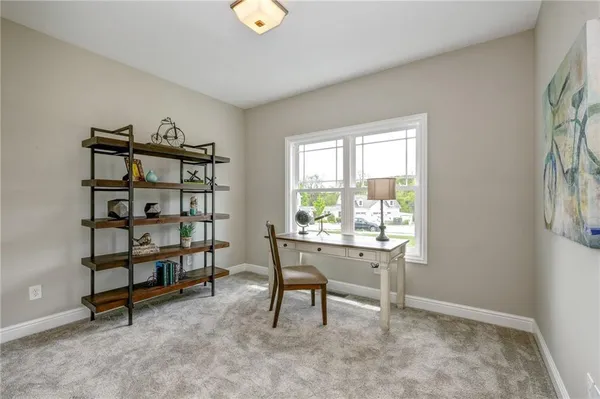 a view of a workspace with furniture and a window