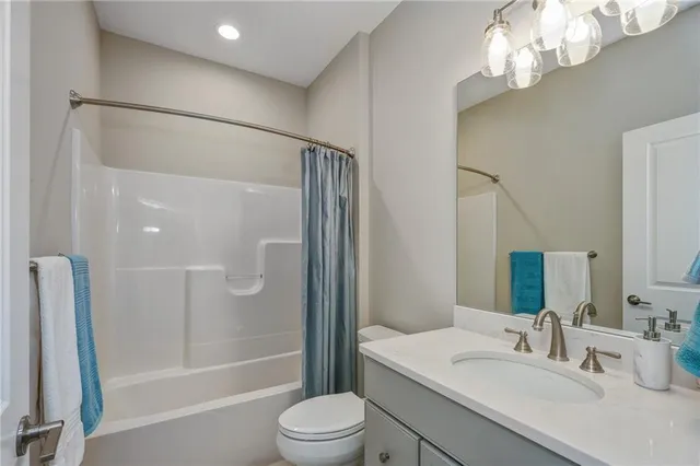 a bathroom with a sink a toilet a mirror and shower