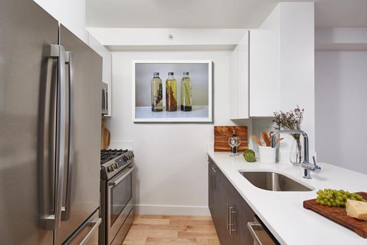 a kitchen with stainless steel appliances a sink and a refrigerator