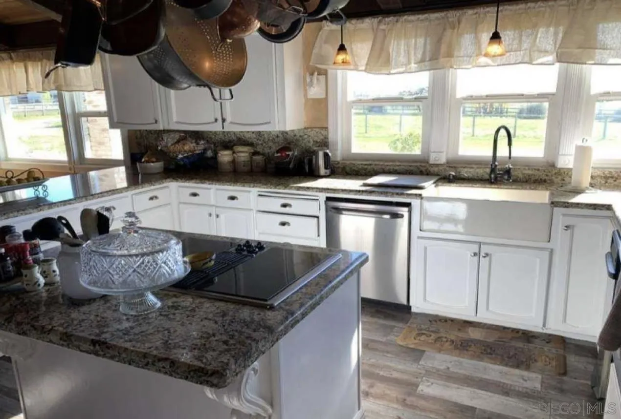 19901 Atkins Road Lodi, CA 95240 - Photo 11 of 27 a kitchen with stainless steel appliances granite countertop a sink a stove and a wooden floors