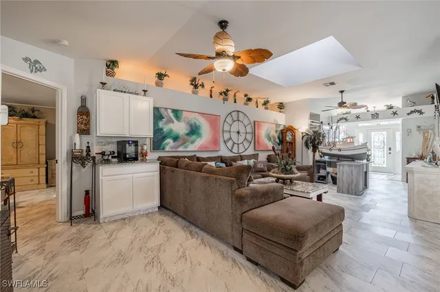 a living room with furniture kitchen view and a chandelier