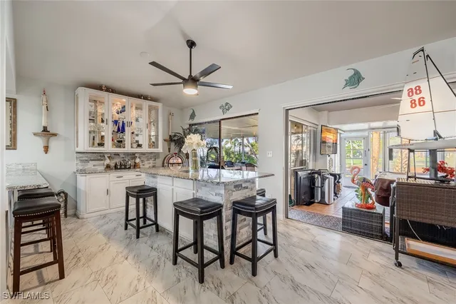 a kitchen with stainless steel appliances granite countertop table chairs sink and stove