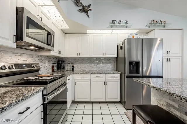 a large kitchen with granite countertop a stove and a sink