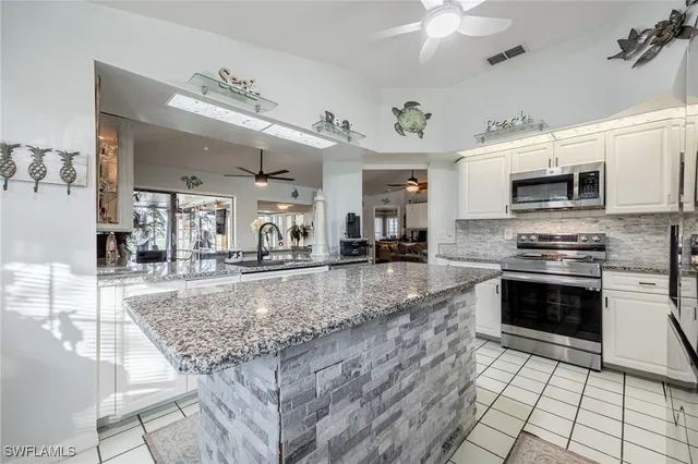a kitchen with center island and chairs in it