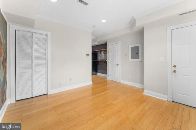 a view of an empty room with wooden floor