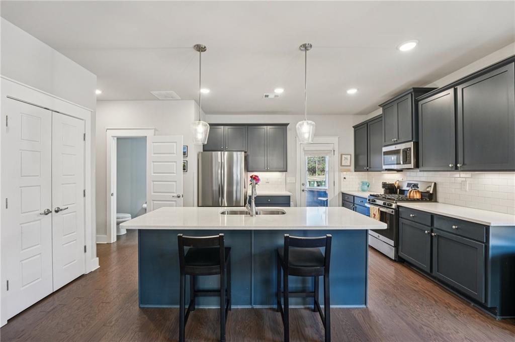 5175 North Pratt Street Covington, GA 30014 - Photo 19 of 52 a kitchen with stainless steel appliances kitchen island granite countertop a dining table chairs and sink