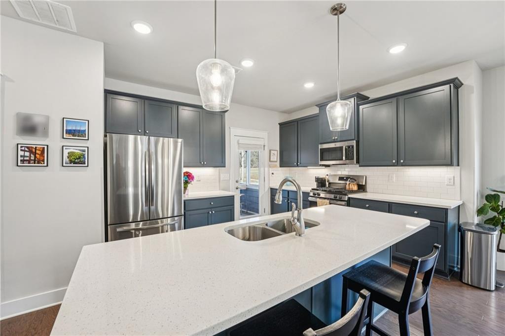 5175 North Pratt Street Covington, GA 30014 - Photo 20 of 52 a kitchen with stainless steel appliances a table chairs and refrigerator