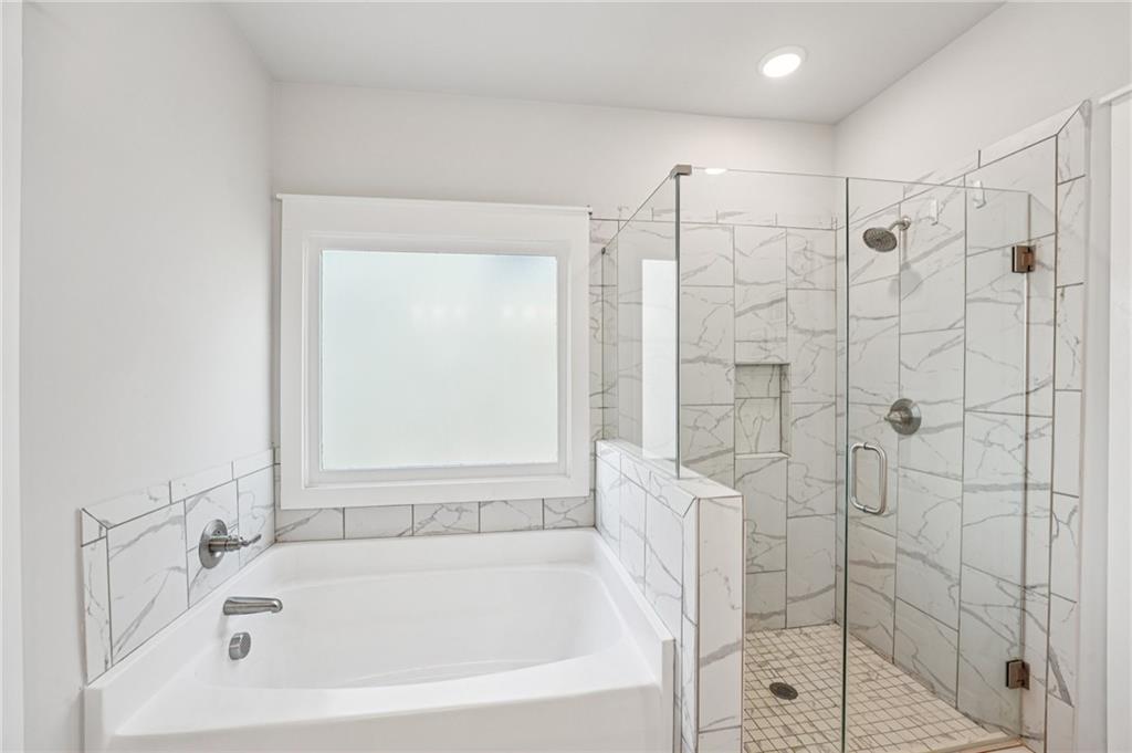5175 North Pratt Street Covington, GA 30014 - Photo 35 of 52 a white bath tub sitting next to a shower