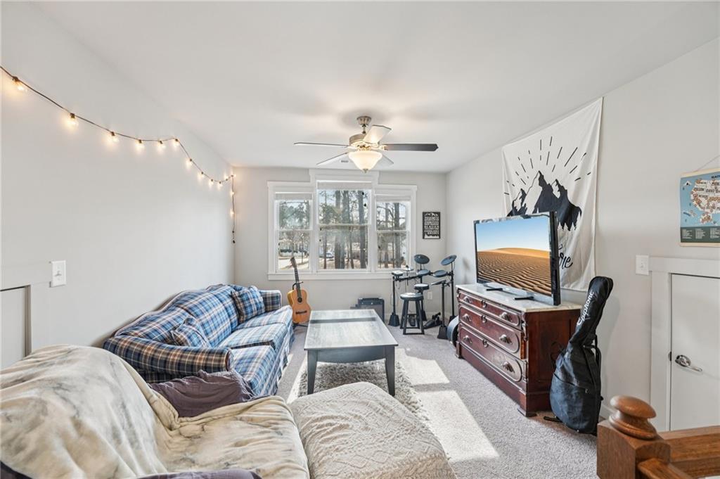 5175 North Pratt Street Covington, GA 30014 - Photo 39 of 52 a living room with furniture a chandelier and a flat screen tv