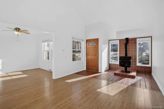 a view of a livingroom with wooden floor and a ceiling fan