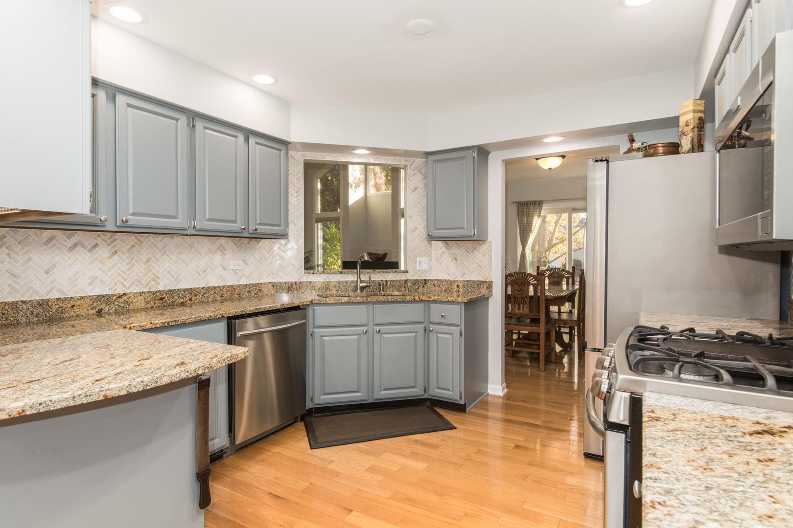 1068 Mattande Lane Naperville, IL 60540 - Photo 7 of 37 a kitchen with stainless steel appliances granite countertop a stove a sink and a refrigerator