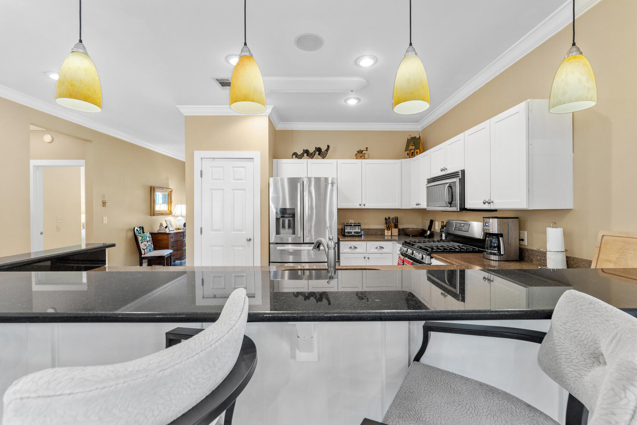 64 Spotted Dolphin Road Santa Rosa Beach, FL 32459 - Photo 7 of 43 a kitchen with stainless steel appliances kitchen island granite countertop a refrigerator a stove a microwave oven a sink a dining table and chairs with wooden floor