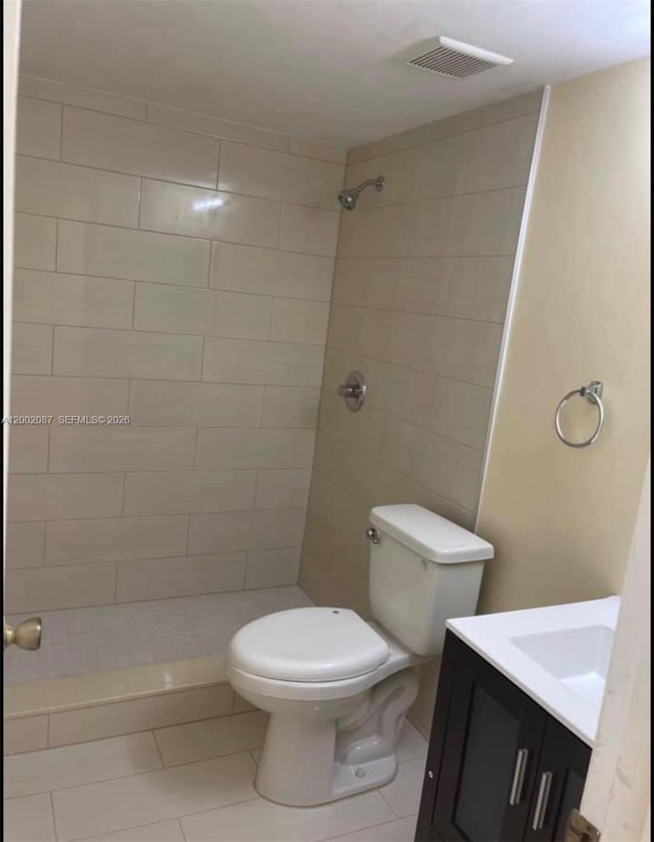 6795 Southwest 132nd Avenue, Unit 203 Miami, FL 33183 - Photo 7 of 9 a white toilet and a shower in a bathroom