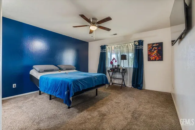 a spacious bedroom with a bed and ceiling fan