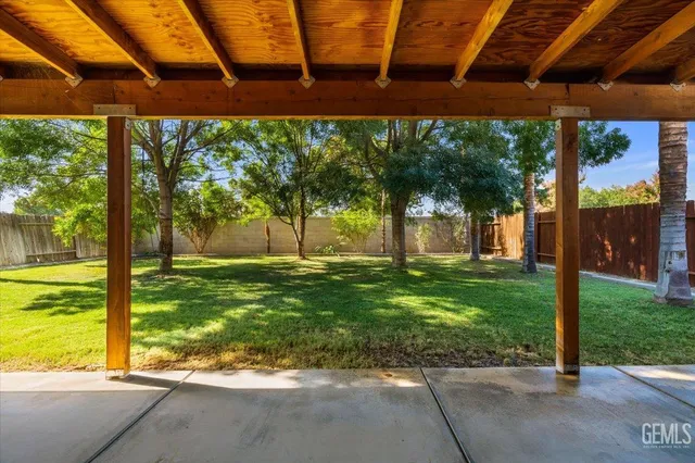 a view of a patio with a table and chairs under an umbrella