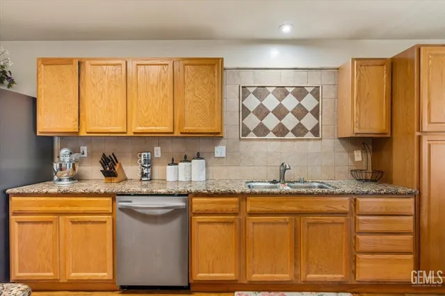 a kitchen with stainless steel appliances granite countertop a sink stove and cabinets