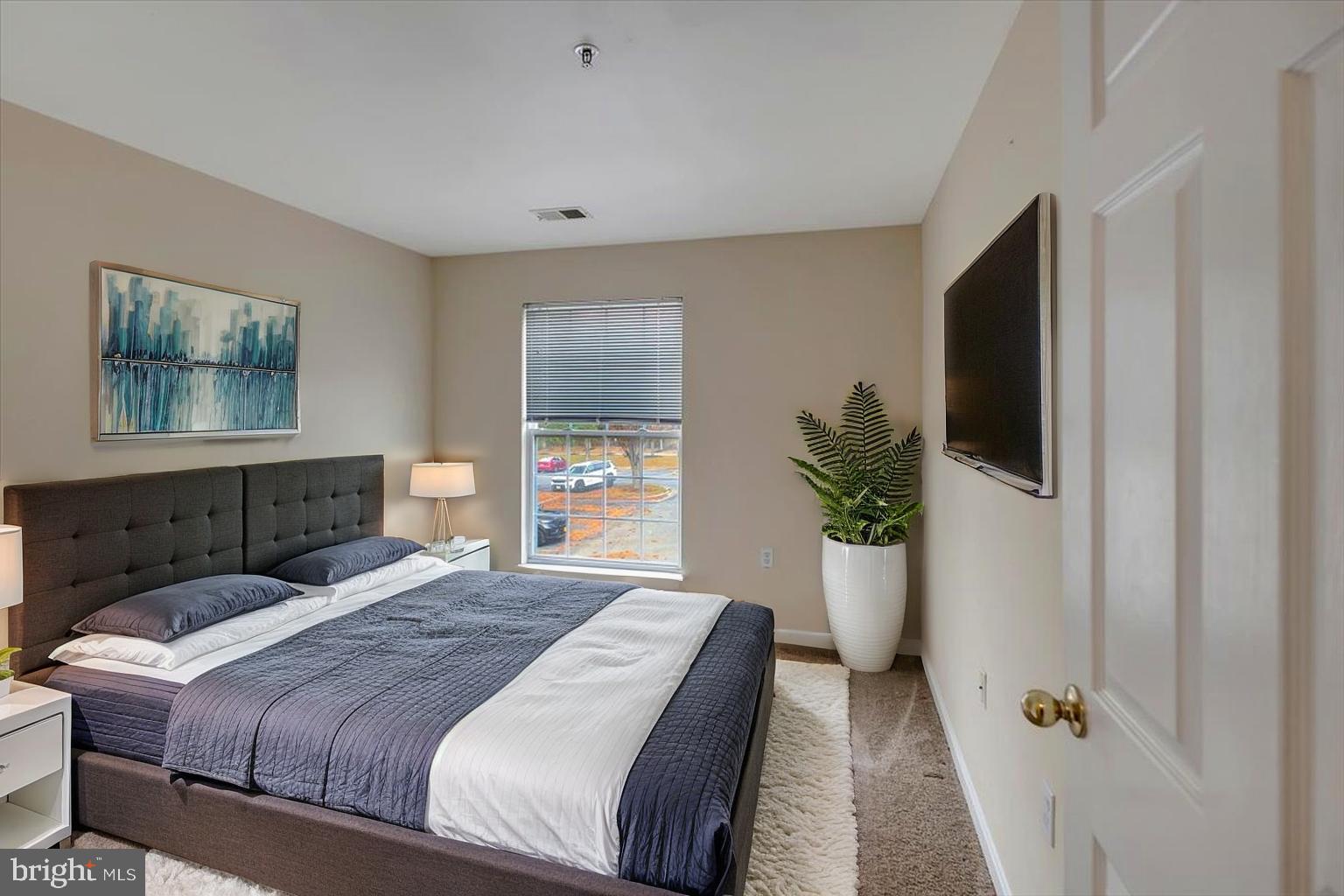 4828 Stone Shop Circle, Unit 4828 Owings Mills, MD 21117 - Photo 13 of 18 a bedroom with a large bed and a potted plant