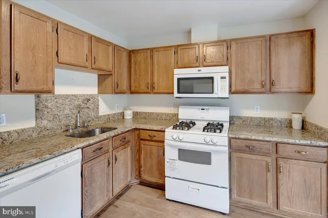a kitchen with a stove a sink and a refrigerator