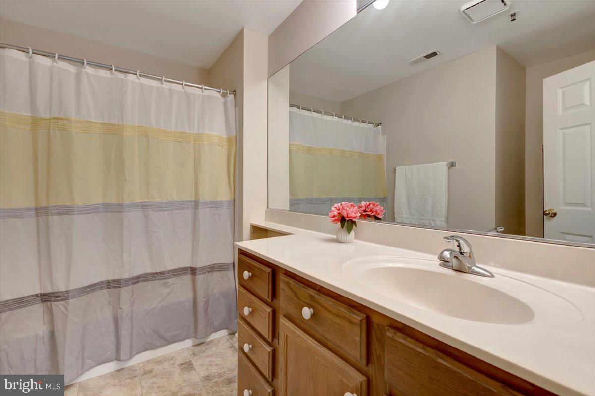 4828 Stone Shop Circle, Unit 4828 Owings Mills, MD 21117 - Photo 10 of 18 a bathroom with a double vanity sink and a mirror