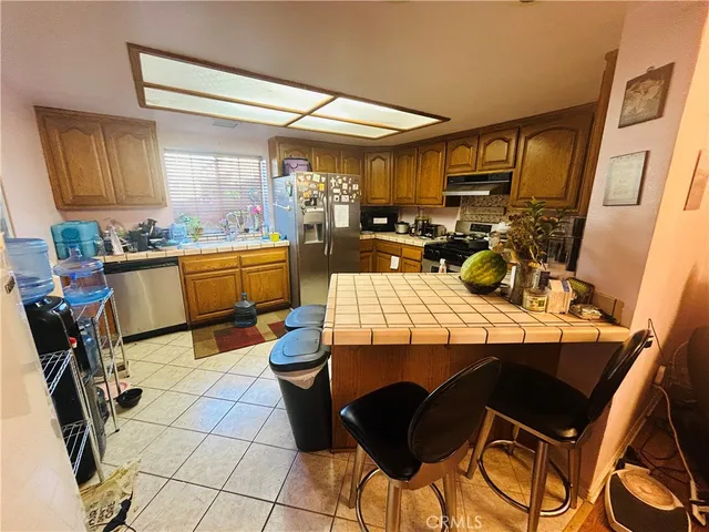 a kitchen with a sink a stove and chairs