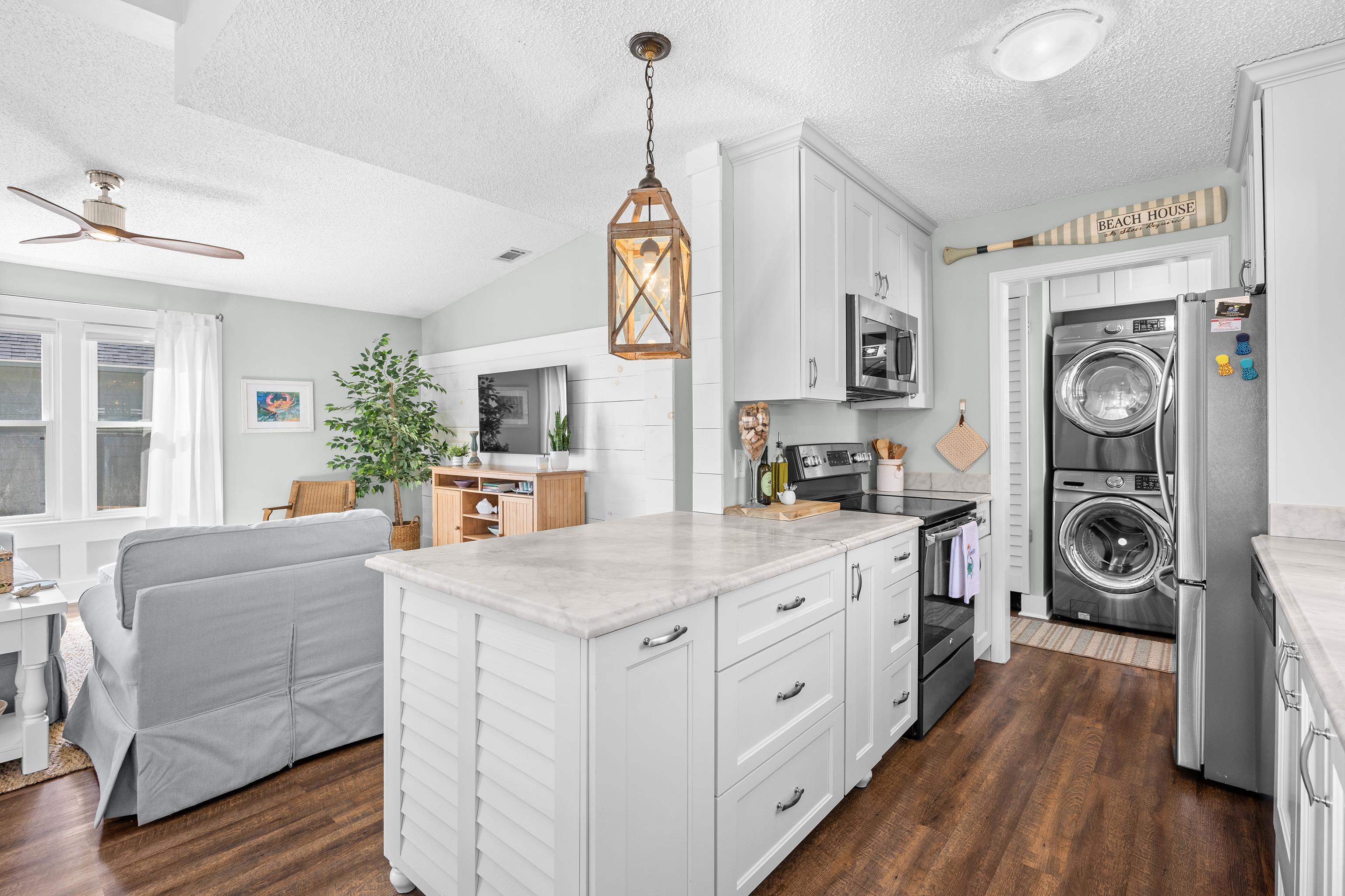 817 Main Sail Court Murrells Inlet, SC 29576 - Photo 35 of 35 Kitchen featuring open floor plan, stainless steel appliances, estacked washer and dryer, hanging light fixtures, and white cabinets