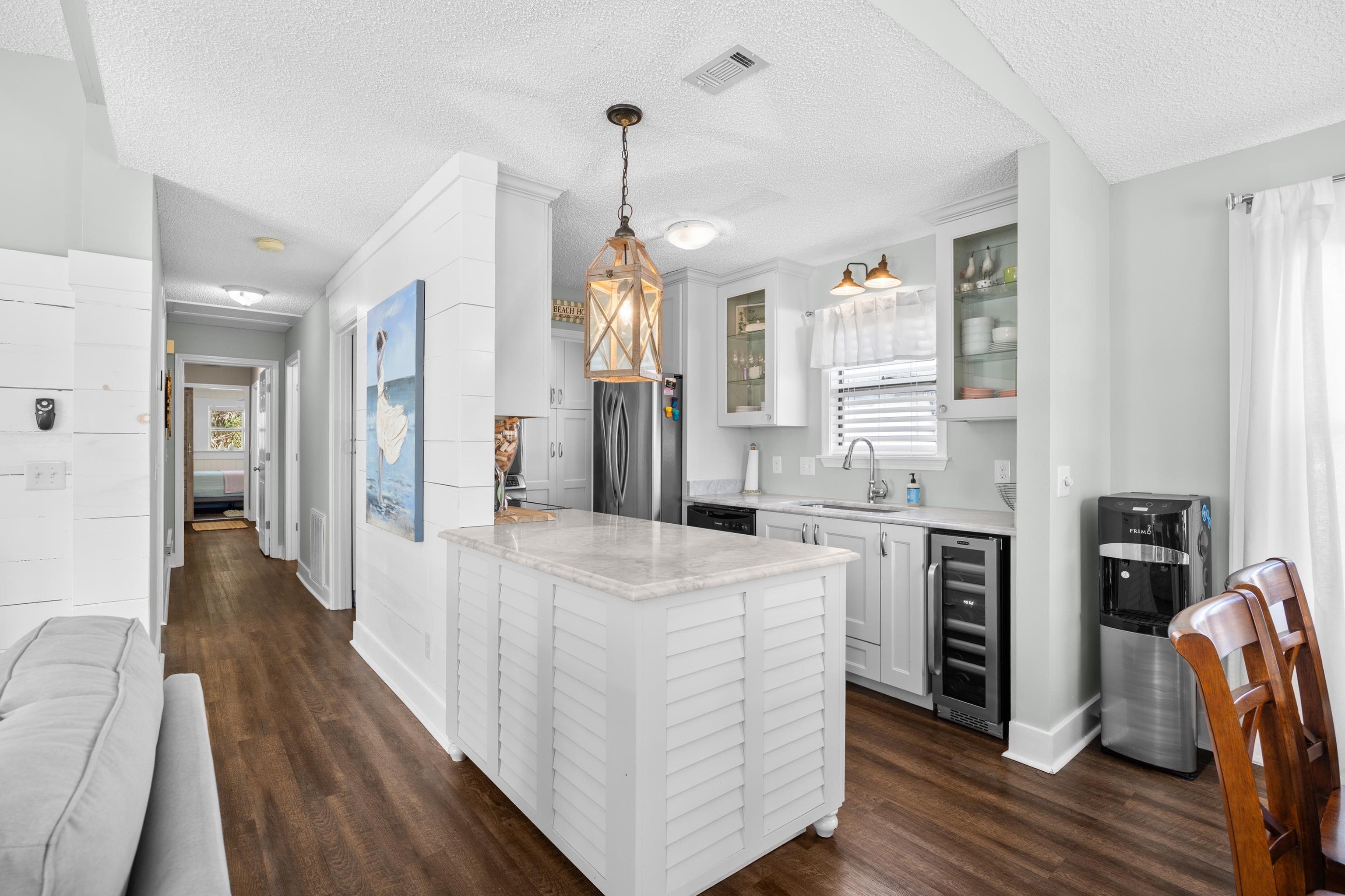 817 Main Sail Court Murrells Inlet, SC 29576 - Photo 10 of 35 Kitchen with pendant lighting, wine cooler, white cabinets, light stone countertops, and dark wood-style flooring