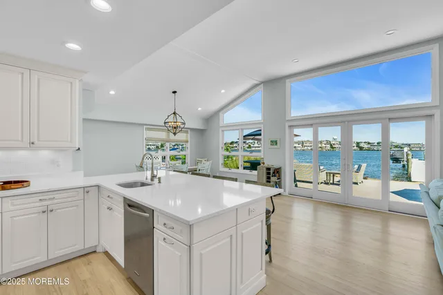 a kitchen with a sink stove and wooden floor