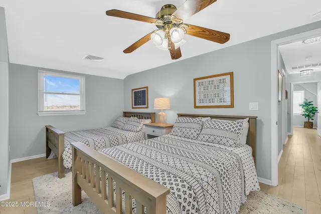 a bedroom with two beds and painting on the wall