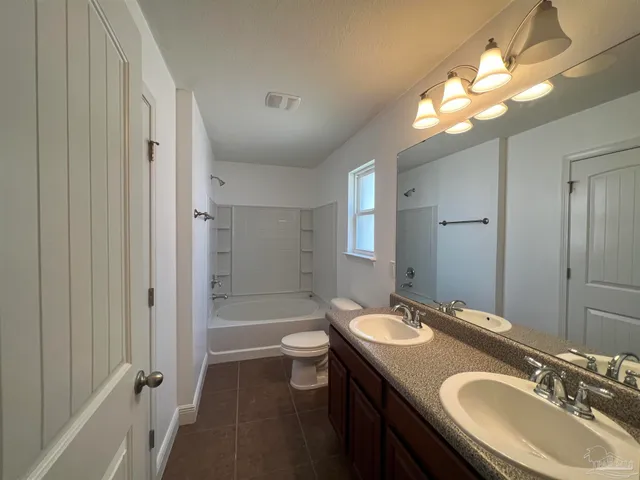 a bathroom with a sink double vanity granite tub and a mirror