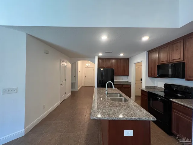 a kitchen with stainless steel appliances granite countertop a sink a stove and a refrigerator