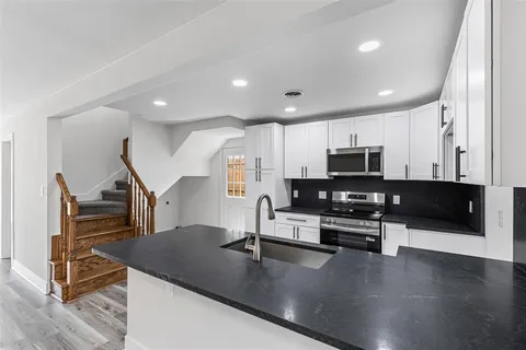a kitchen with stainless steel appliances a refrigerator a sink a stove a microwave and island