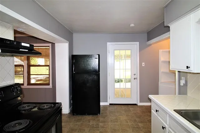 a kitchen with a refrigerator and a stove top oven