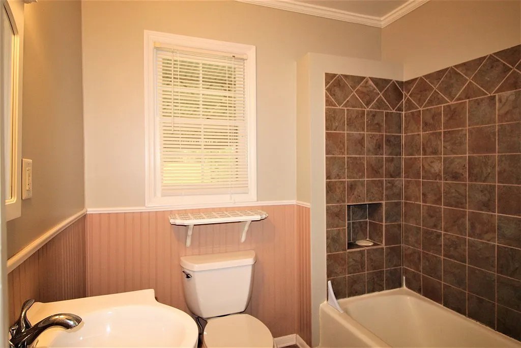 4317 Byron Street Columbus, GA 31907 - Photo 19 of 28 a bathroom with a toilet a sink and bathtub