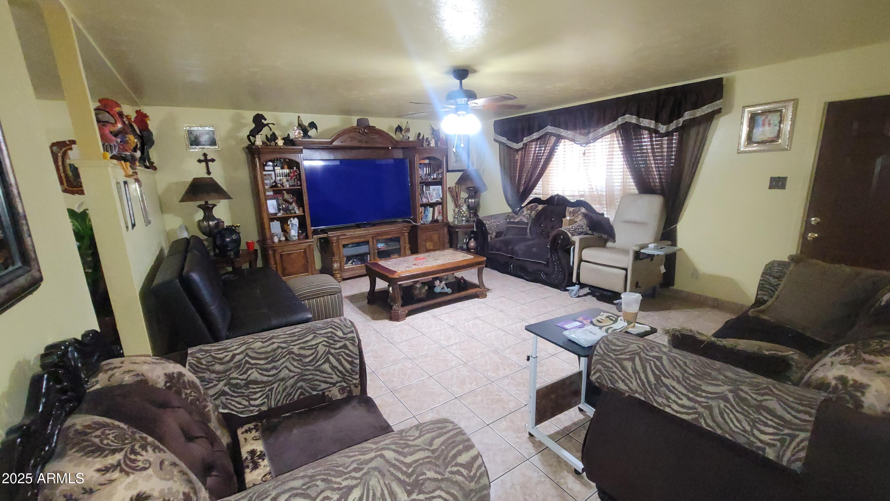 4315 West Osborn Road Phoenix, AZ 85031 - Photo 16 of 29 a living room with furniture and a flat screen tv