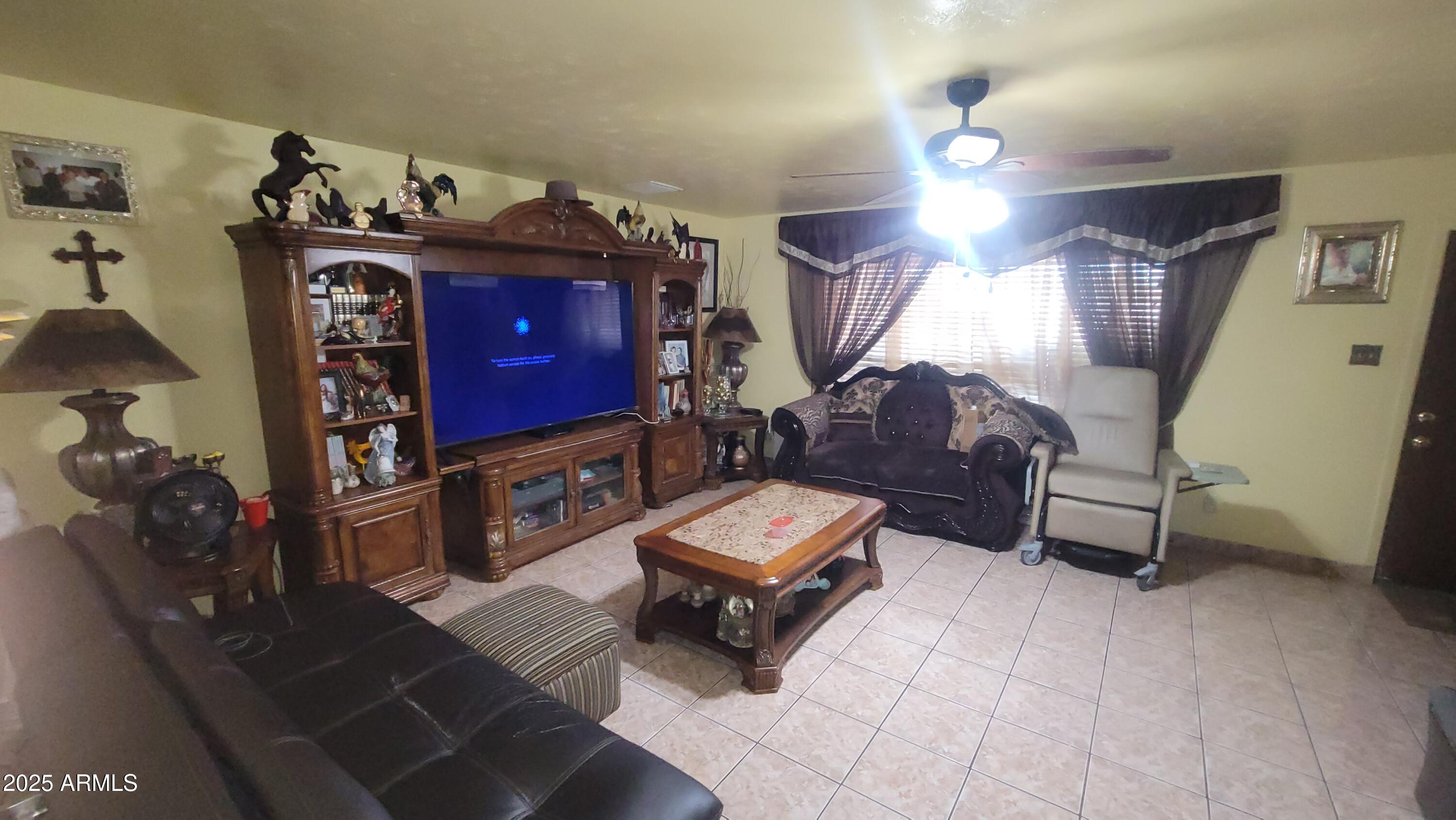 4315 West Osborn Road Phoenix, AZ 85031 - Photo 21 of 29 a living room with furniture and a flat screen tv