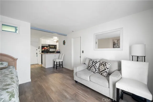 a living room with furniture and a dining table with wooden floor