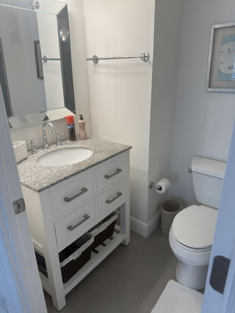 3215 South Ocean Boulevard, Unit 210 Highland Beach, FL 33487 - Photo 5 of 9 a bathroom with a granite countertop toilet sink and mirror