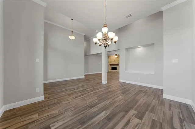 a view of a room with wooden floor and chandelier