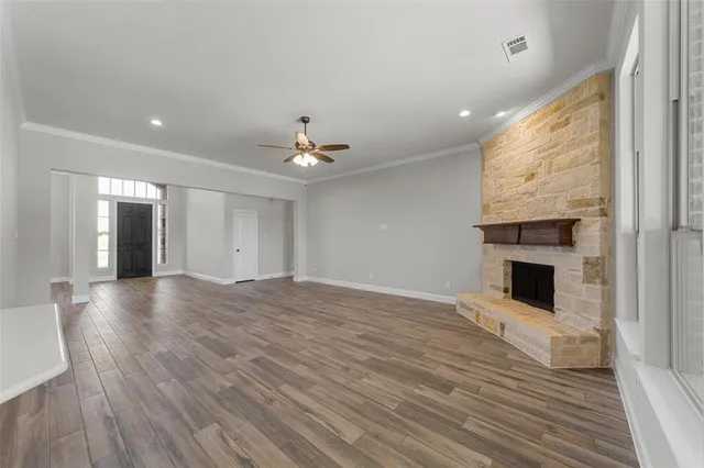 a view of a livingroom with a fireplace wooden floor and window