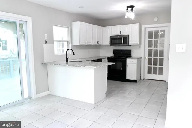 a kitchen with stainless steel appliances granite countertop a stove top oven a sink a refrigerator and a granite counter tops