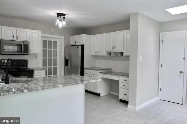 a kitchen with stainless steel appliances granite countertop a stove refrigerator and microwave