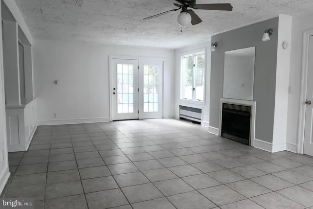 a view of an empty room with a fireplace and a window