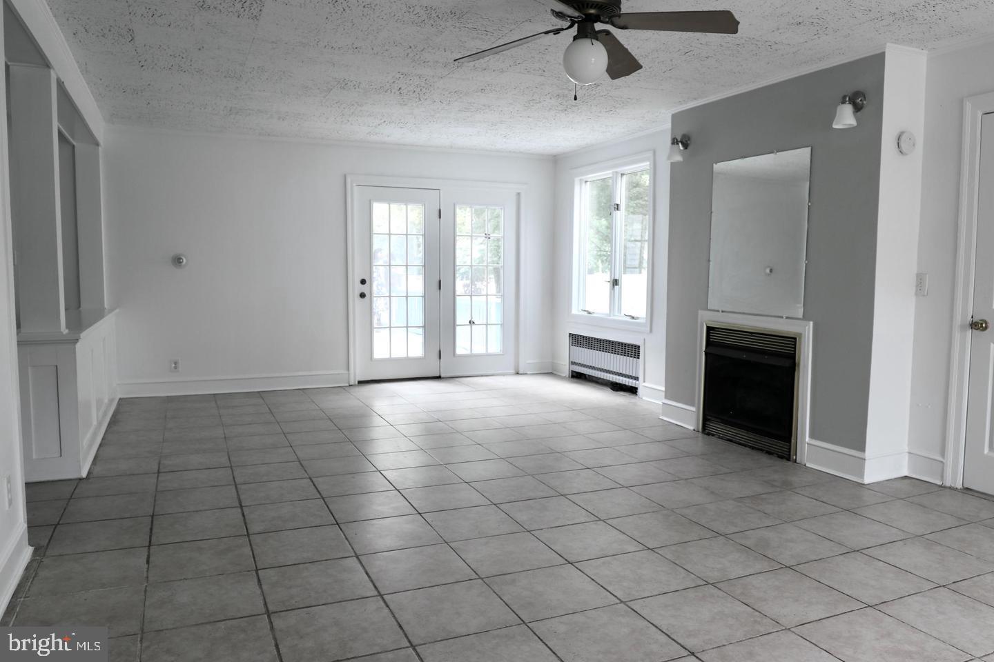 149 South Main Street, Unit 1 Elmer, NJ 08318 - Photo 6 of 14 a view of an empty room with a fireplace and a window