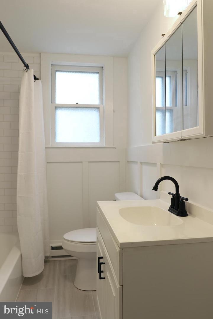 149 South Main Street, Unit 1 Elmer, NJ 08318 - Photo 10 of 14 a bathroom with a sink a toilet and a window