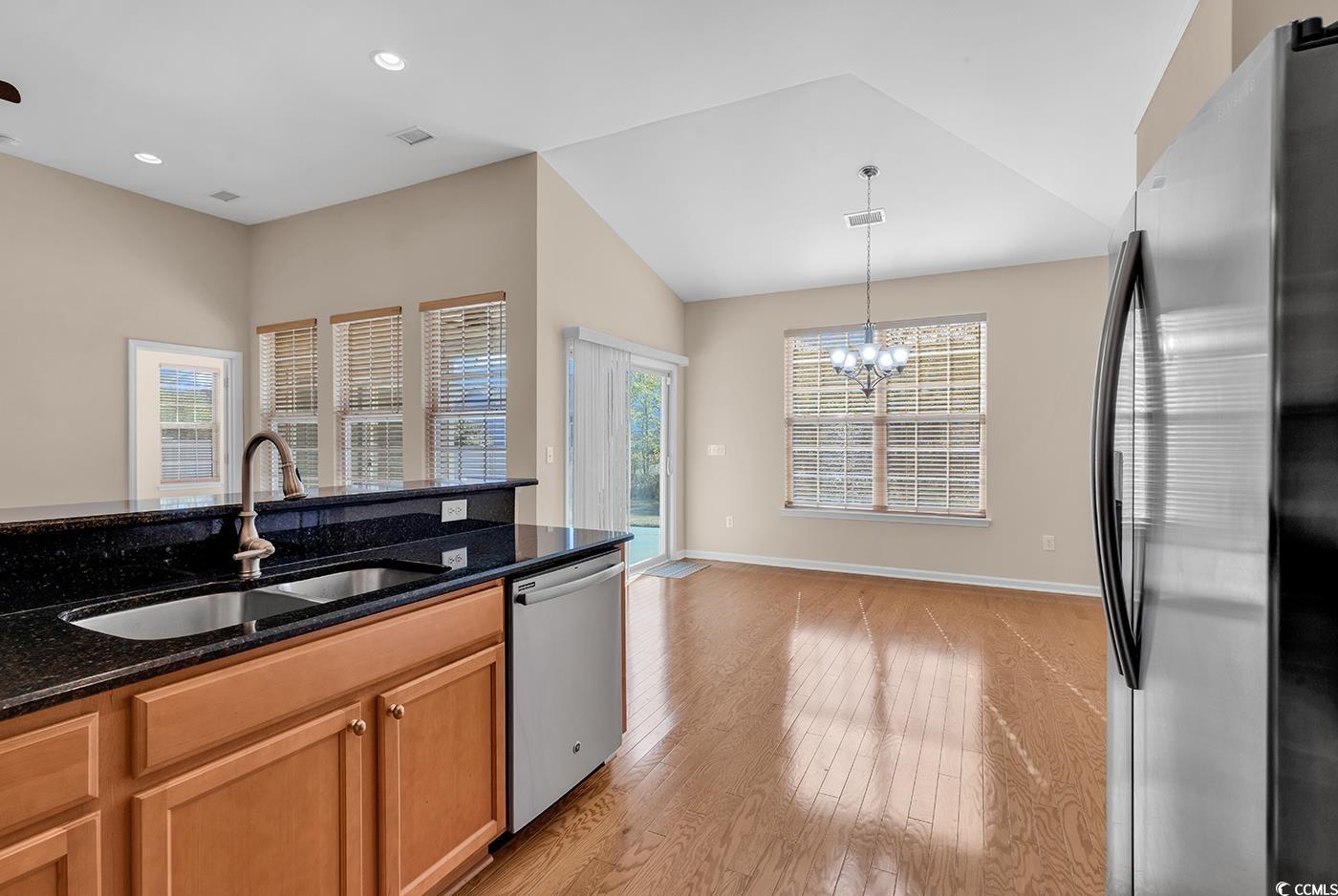 1612 Fairforest Court Conway, SC 29526 - Photo 11 of 40 Kitchen featuring appliances with stainless steel finishes, dark stone counters, plenty of natural light, light wood-type flooring, and lofted ceiling