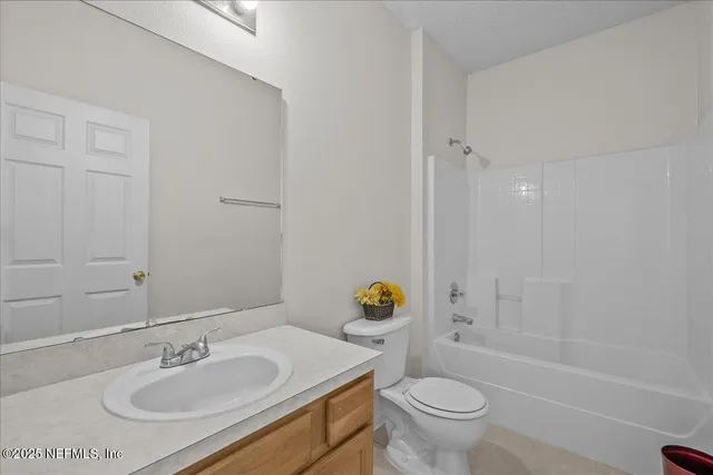 a bathroom with a granite countertop sink a toilet and shower