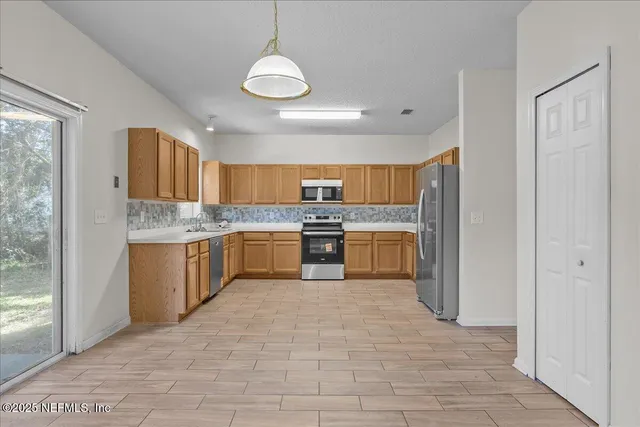 a large kitchen with cabinets and stainless steel appliances