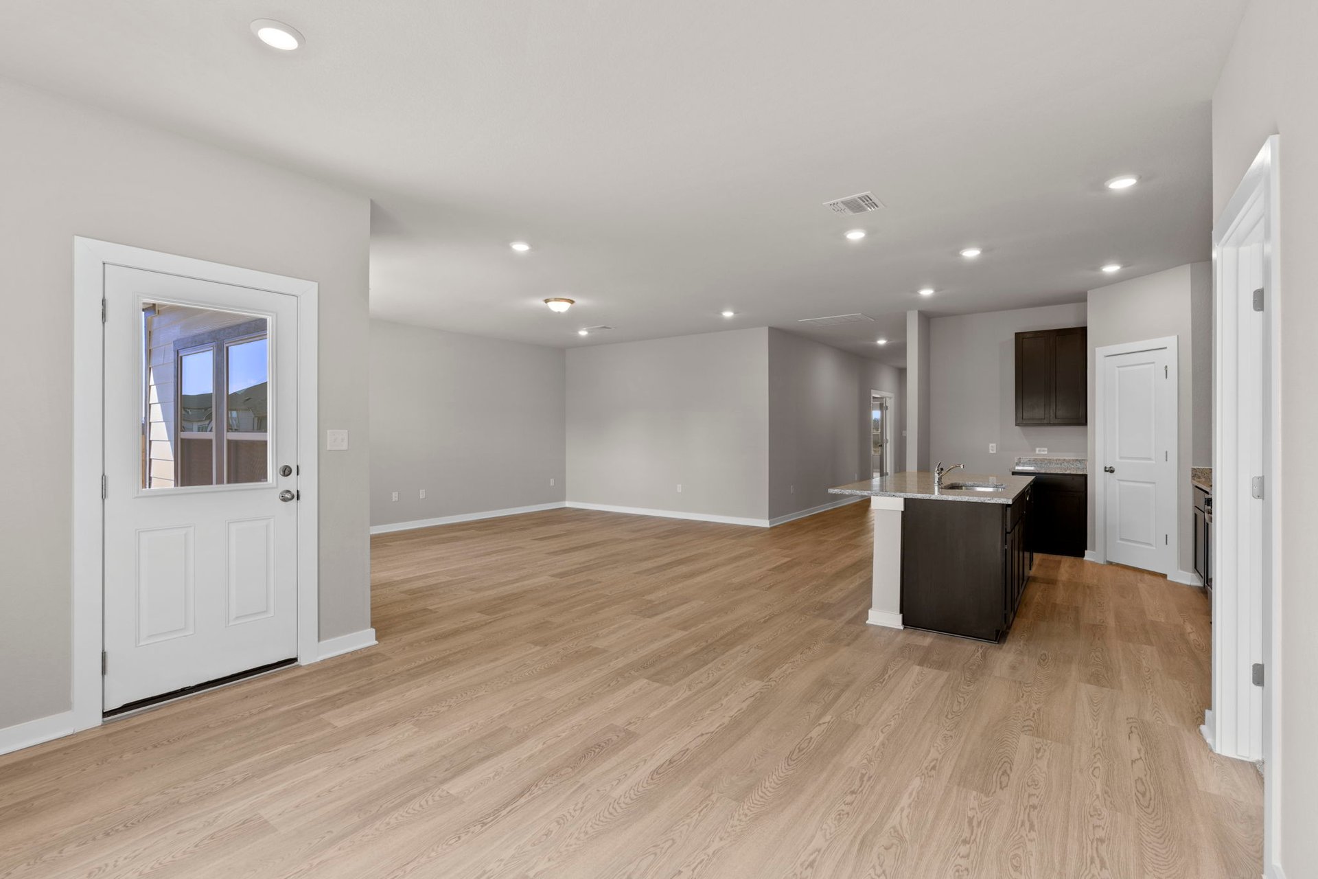 13613 Gray Landing Drive Elgin, TX 78621 - Photo 12 of 33 a view of a big room with wooden floor and a kitchen